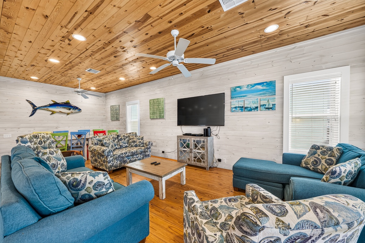 Gather with your group in this spacious coastal retreat, where plush seating, warm wood tones, and playful nautical touches create the perfect spot to unwind together.