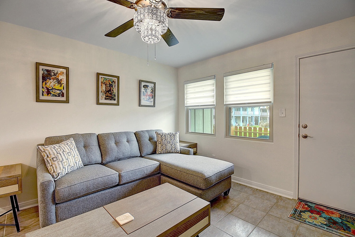 Sink into your cozy sectional sofa while enjoying natural light streaming through your windows and the gentle breeze from your ceiling fan.