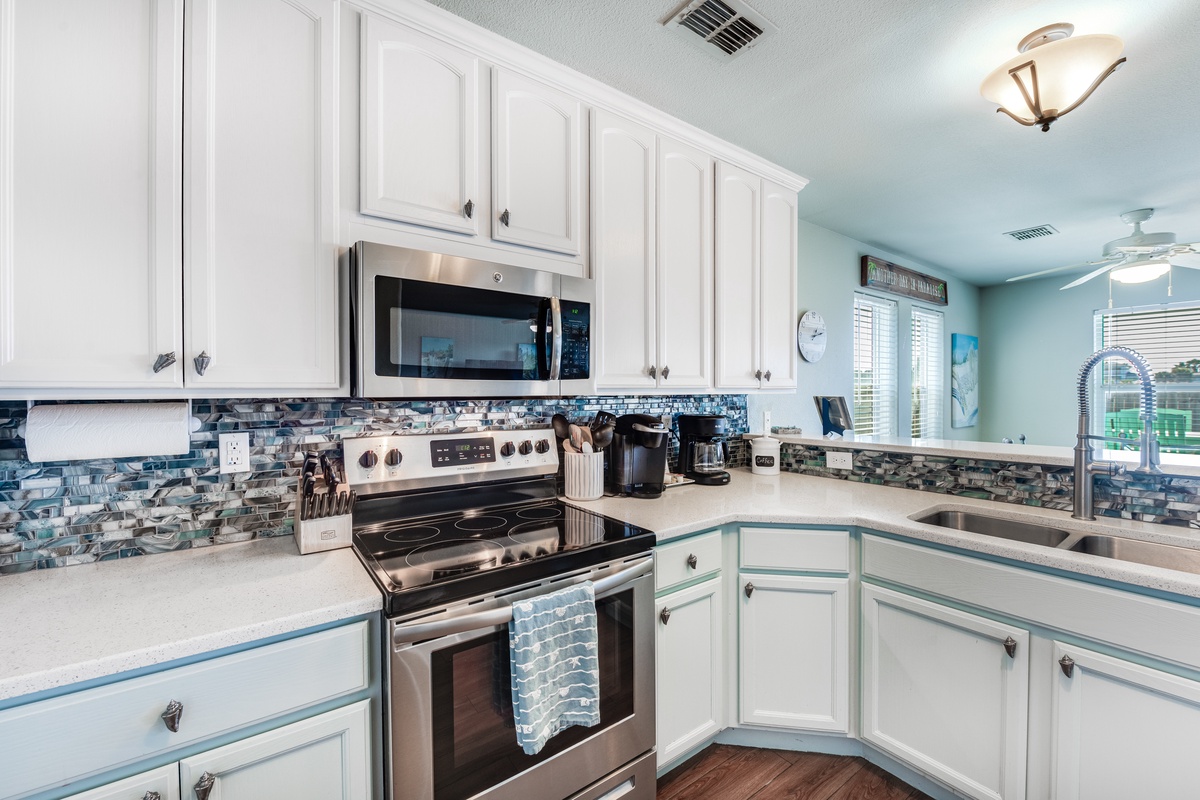 Your fully equipped kitchen awaits with stainless steel appliances, ocean-inspired backsplash, and all the tools you need to create memorable meals together.