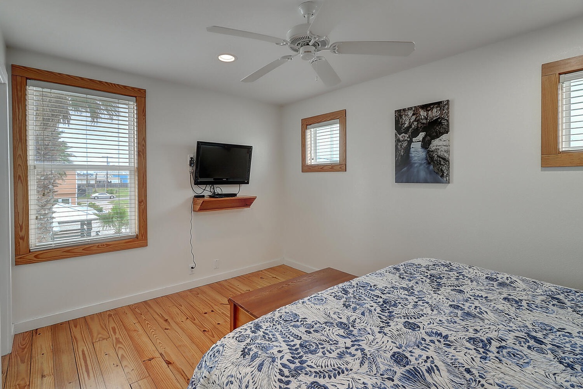 Your peaceful bedroom features beautiful blue paisley bedding, ceiling fan, and TV entertainment—perfect for unwinding after exploring.