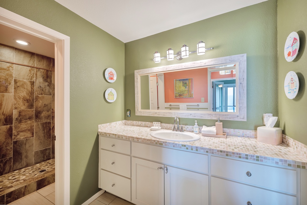 Your spacious bathroom features mosaic tile counters, elegant lighting, and a luxurious stone shower for ultimate relaxation.