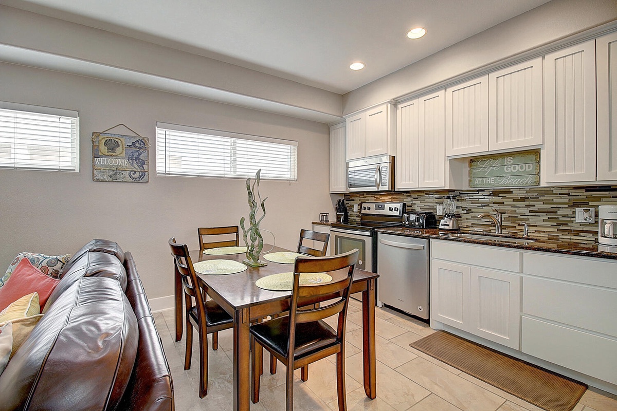 Your open kitchen flows into the dining area where you'll enjoy meals around the warm wood table and unwind on the leather sofa.