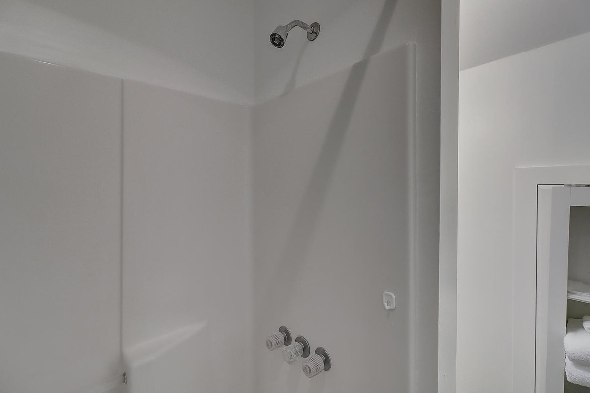 Enjoy your refreshing private shower with clean white surroundings and modern fixtures for ultimate relaxation.