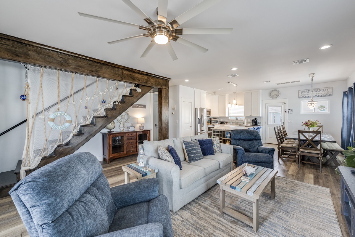 Sink into comfortable coastal vibes in this open living space where your vacation memories unfold beneath soaring ceilings and nautical charm.