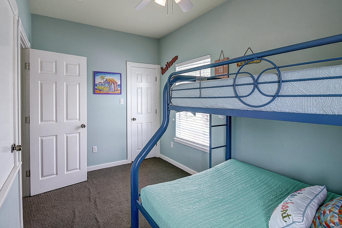 Your kids will love this cheerful blue bunk bed setup, perfect for adventures and cozy nights in this bright, welcoming bedroom.