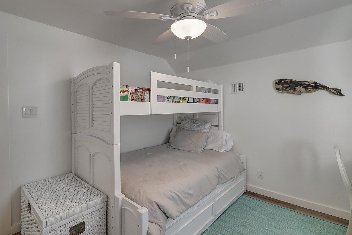 Your kids will love this cozy bunk bed room with its crisp white linens and fun wall art, creating the perfect space for sweet dreams.