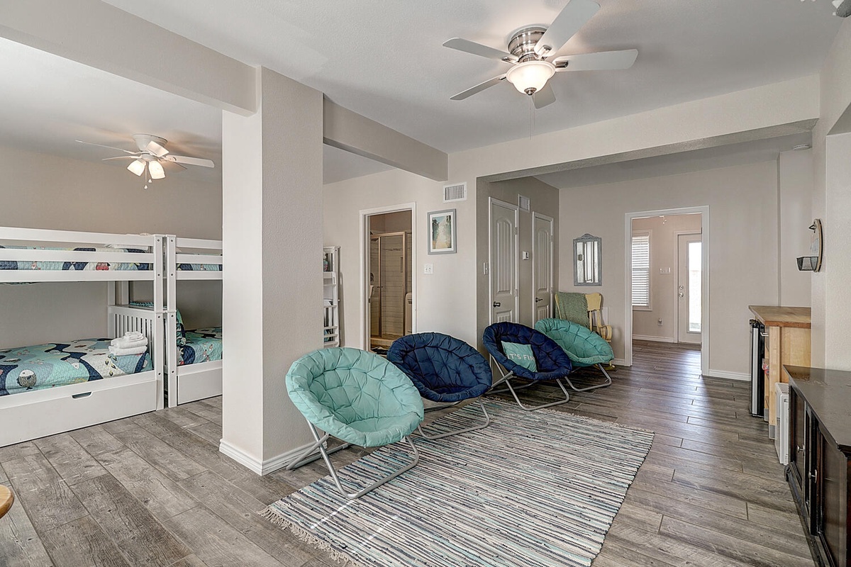 Gather with family in this spacious room featuring cozy bunk beds and comfortable lounge chairs, perfect for relaxing together.