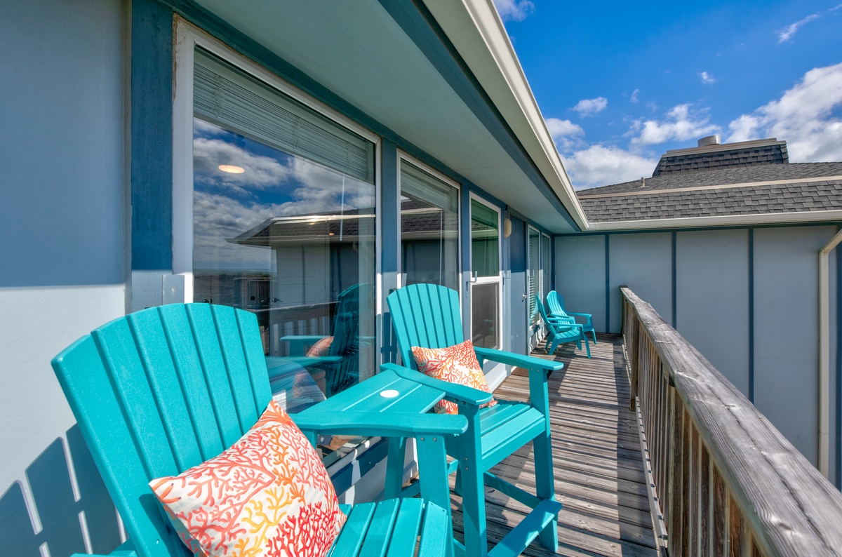 Relax in your vibrant turquoise chairs with colorful pillows on this private balcony, watching clouds drift across brilliant blue skies.