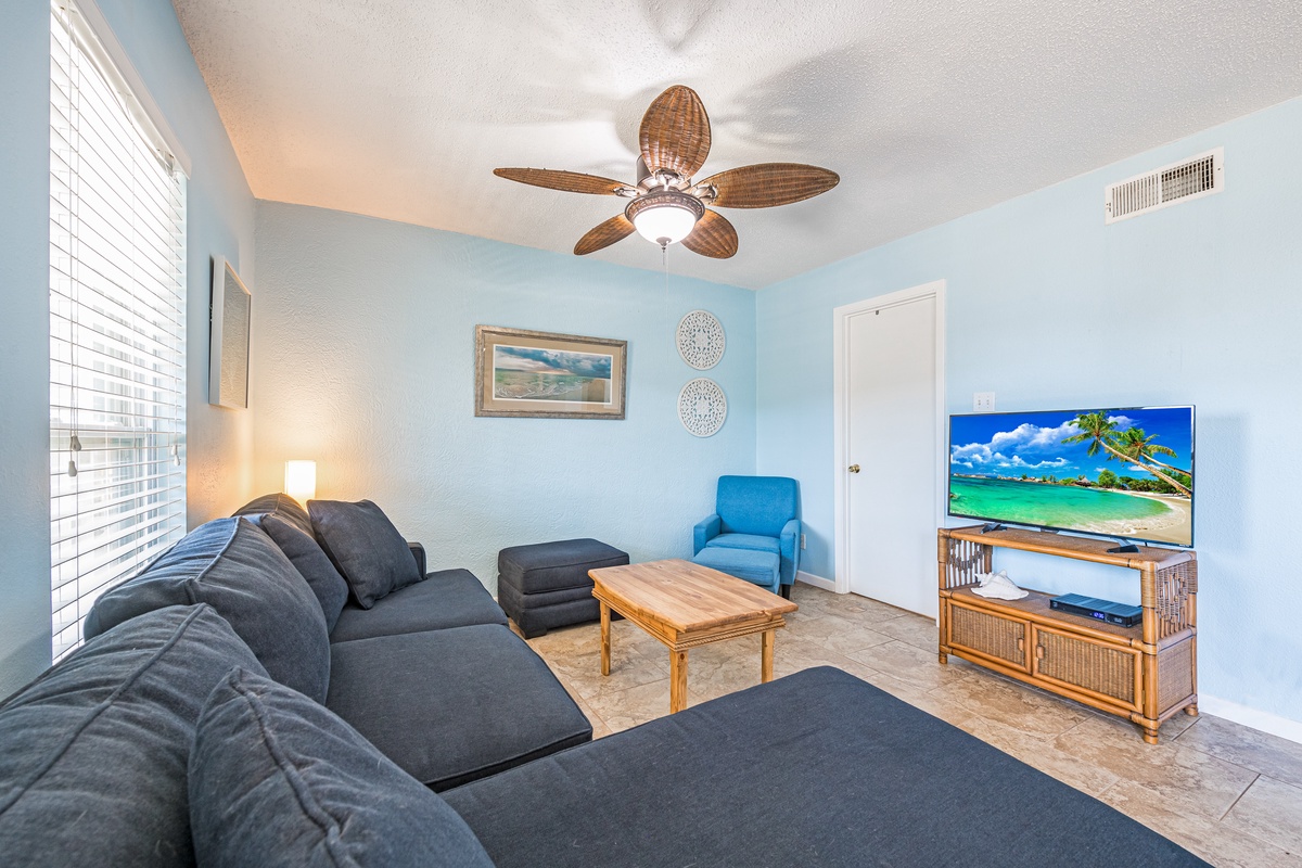 Unwind in your coastal-themed living room with plush seating, tropical ceiling fan, and entertainment center for perfect vacation evenings.