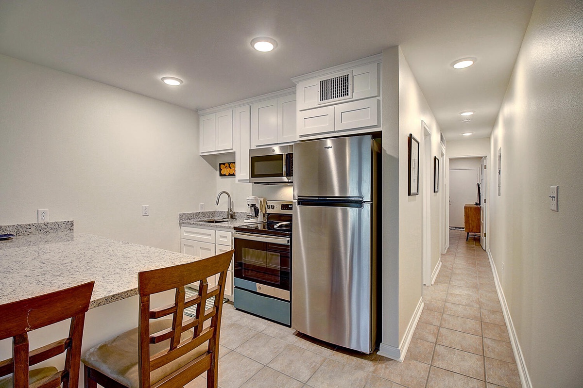 Your fully-equipped kitchen features granite countertops, stainless steel appliances, and ample cabinet space for preparing meals during your stay.
