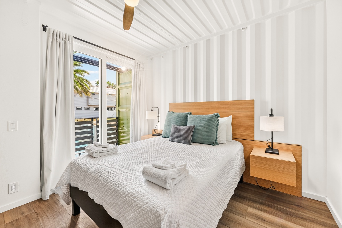 Drift off in your peaceful third bedroom, where a plush queen bed awaits beneath a modern ceiling fan and soft lighting. Fresh towels and elegant fixtures make this your own calm retreat.
