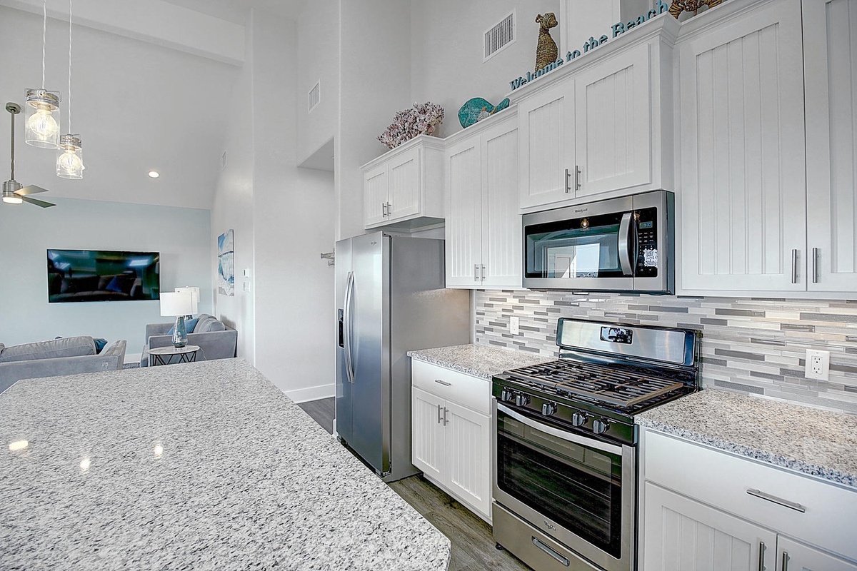 Your spacious kitchen features granite counters, stainless appliances, and coastal charm for memorable meal preparation.