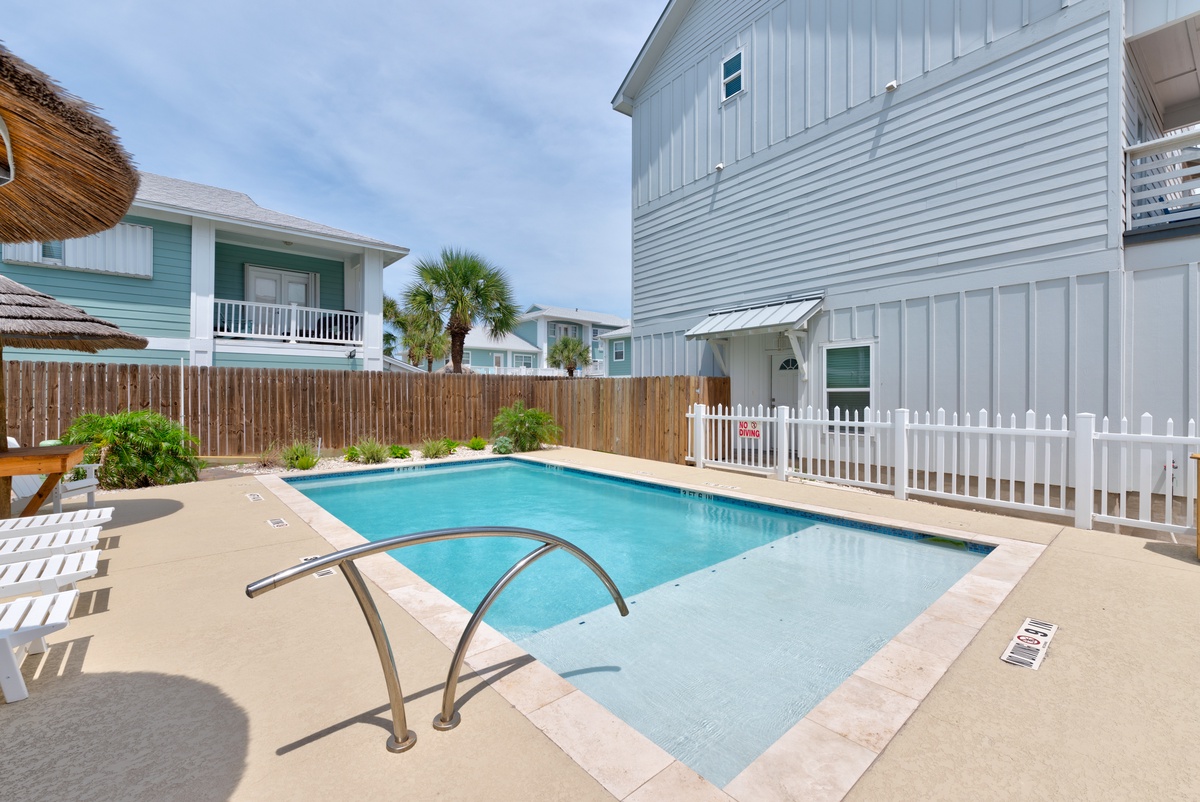 Dive into your private oasis with sparkling pool waters surrounded by coastal charm and tropical palms.