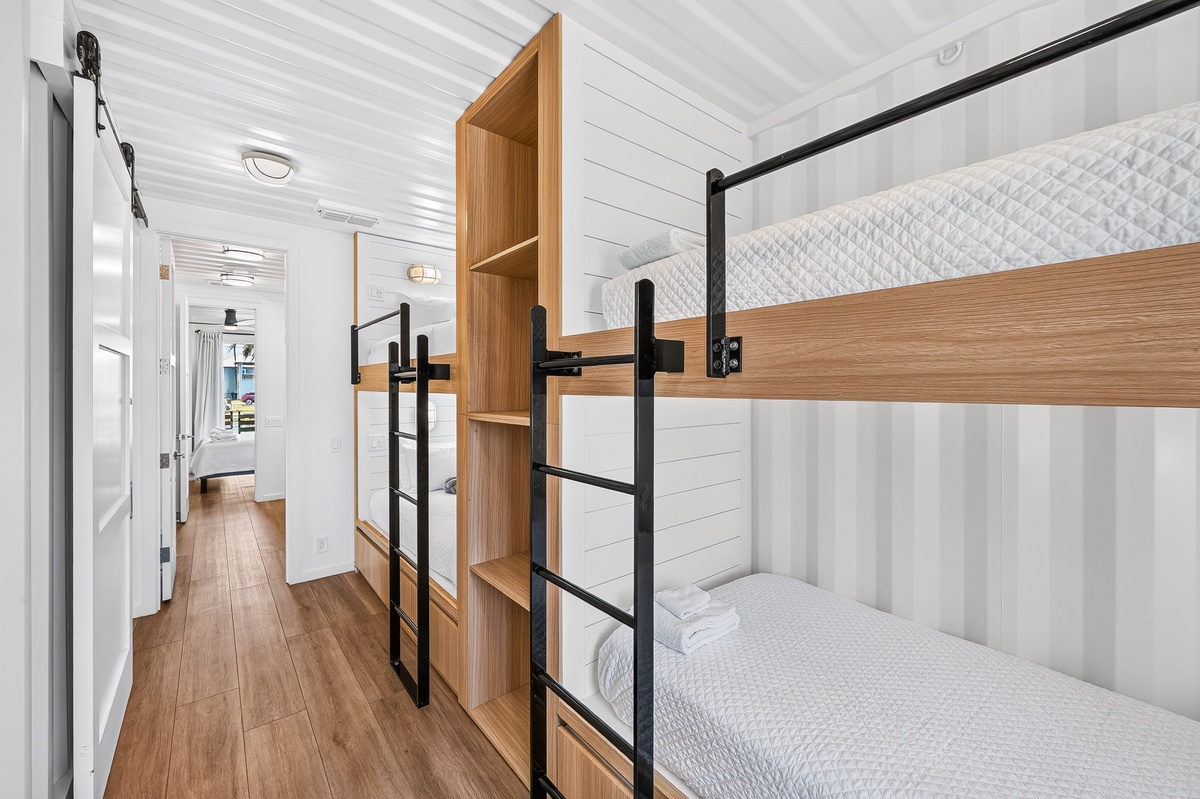 Your cozy twin bunk room with crisp white linens and warm wood accents, perfect for kids or extra guests to rest comfortably after a day of adventure.