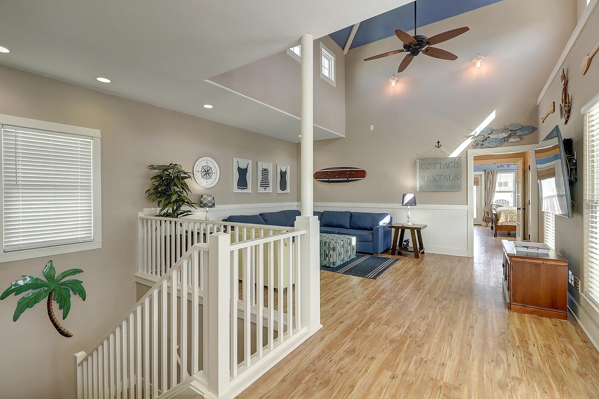 Relax in your coastal-inspired living room with soaring ceilings, nautical decor, and comfortable seating perfect for unwinding after beach days.