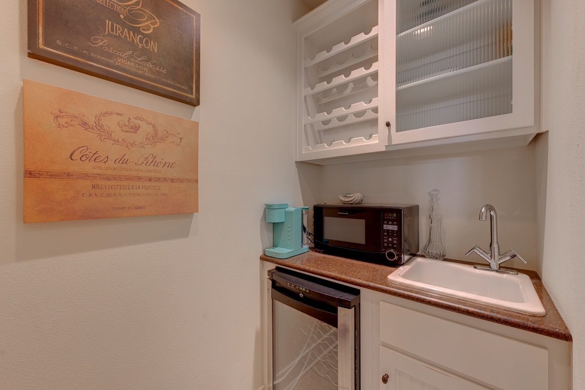 Your charming kitchenette offers everything for cozy meals—microwave, dishwasher, and French wine prints create a warm culinary retreat.