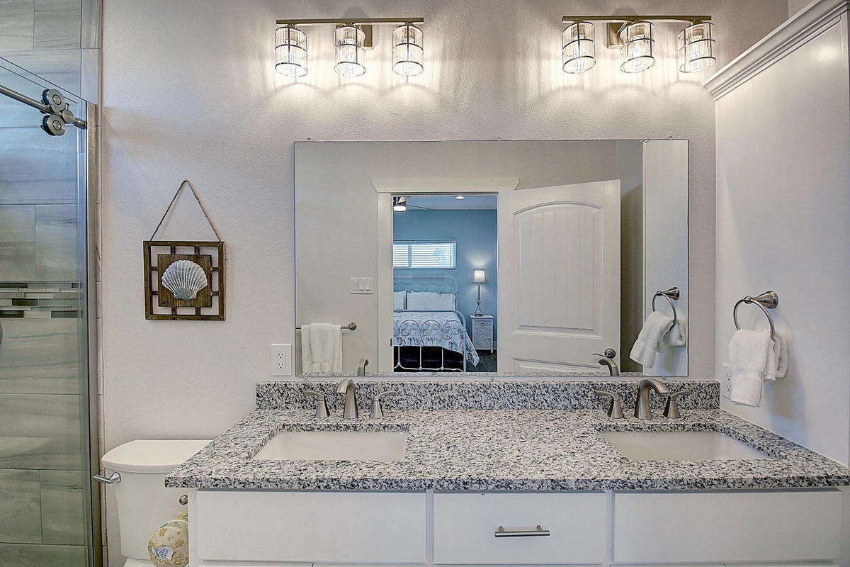 Pamper yourself in this elegant dual-sink vanity with granite countertops, perfect lighting, and fresh towels at your fingertips.