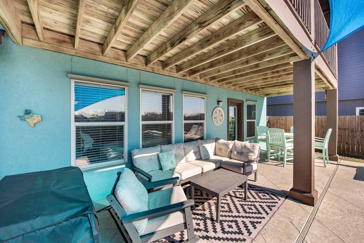 Your covered patio offers coastal-inspired comfort with plush seating under exposed wood beams—perfect for relaxing with morning coffee or evening conversations.
