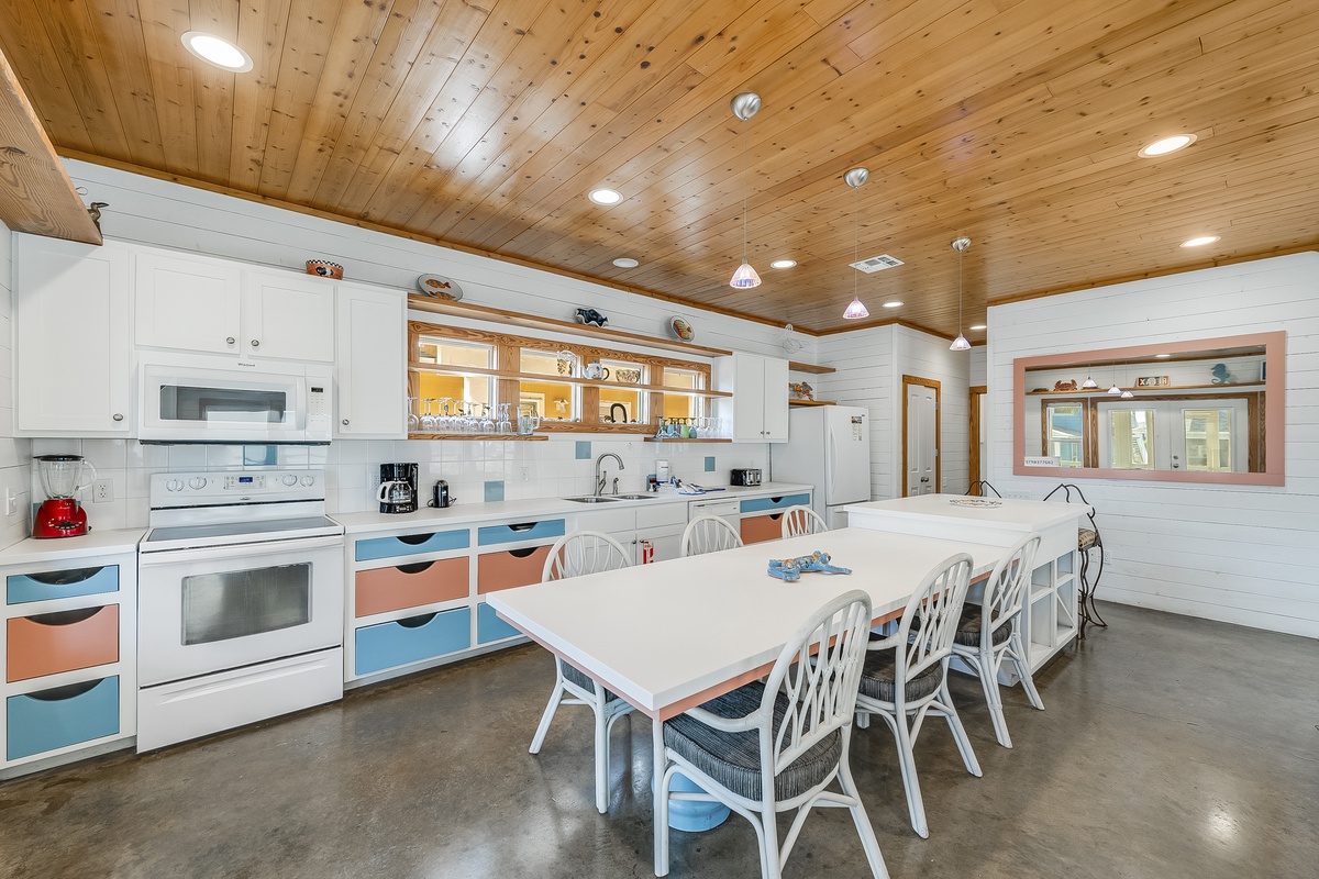 Your spacious kitchen features warm wood ceilings, colorful accents, and a large dining table perfect for family meals and group gatherings.