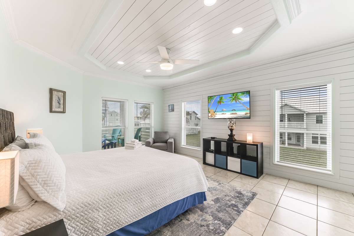 Drift off to sleep in this serene bedroom with coastal charm, featuring a plush bed, smart TV, and peaceful views.