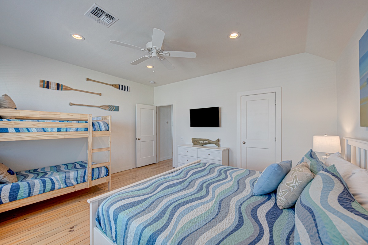 Drift off in this coastal-themed bedroom with ocean blues, bunk beds for kids, and crisp white linens.