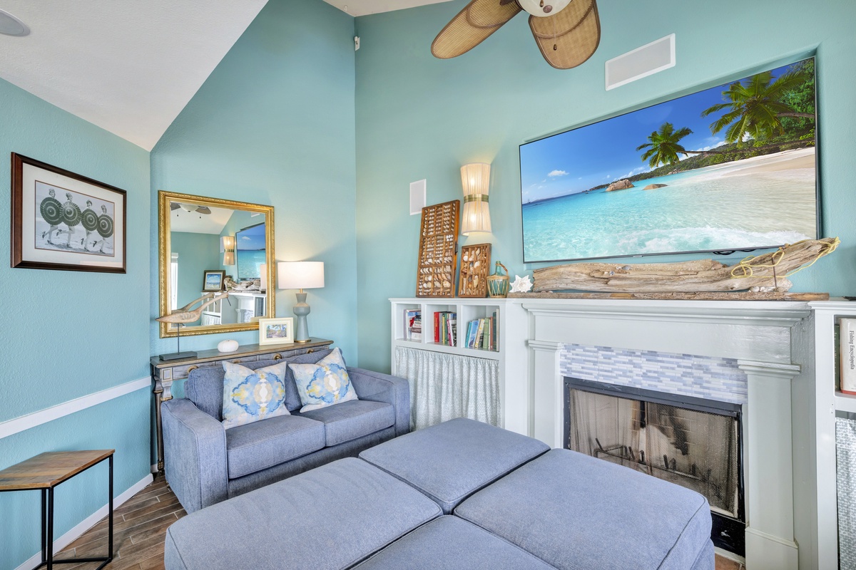 Sink into your cozy coastal retreat with ocean-themed decor, crackling fireplace, and entertainment center for perfect evening relaxation.