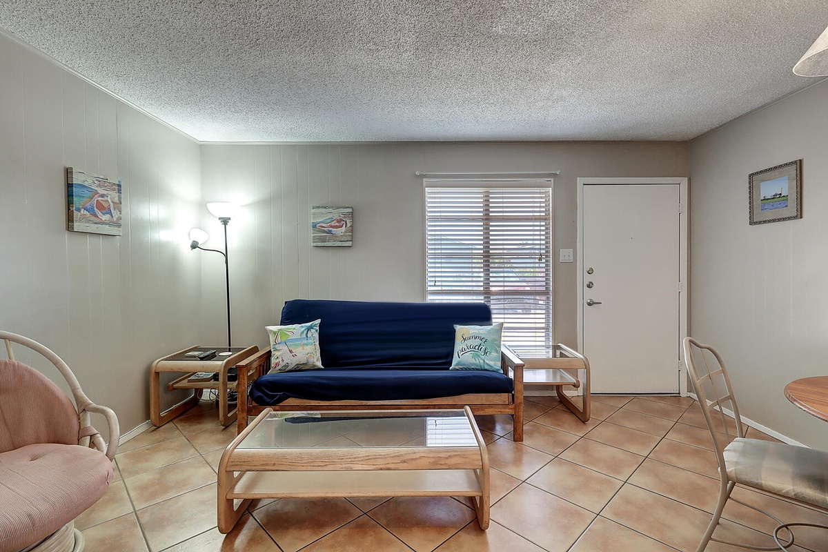 Relax in your comfortable living area with coastal-inspired decor, perfect for unwinding after beach adventures.