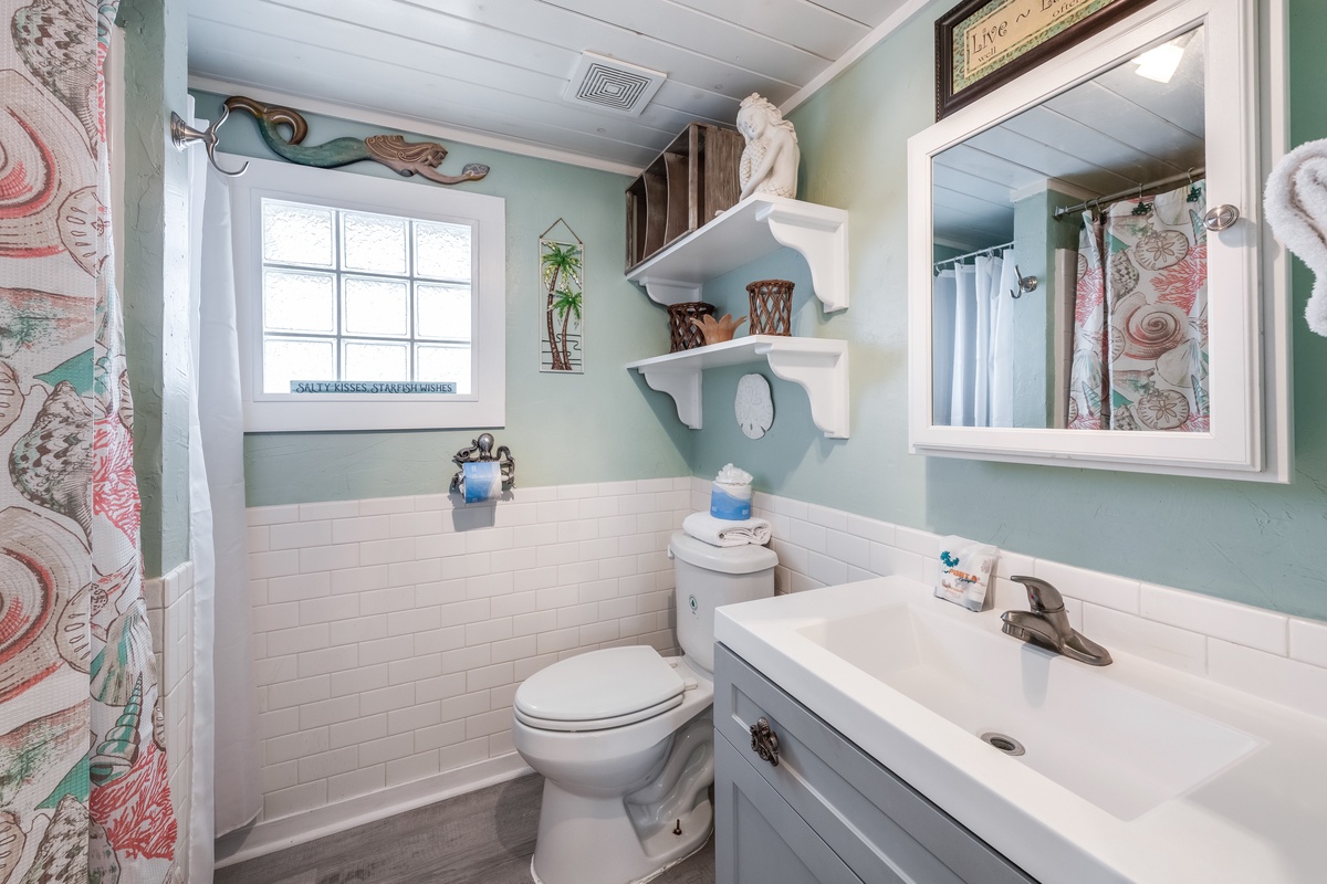 Refresh in your charming coastal bathroom with nautical touches, soft mint walls, and thoughtful amenities that make your stay feel like home.