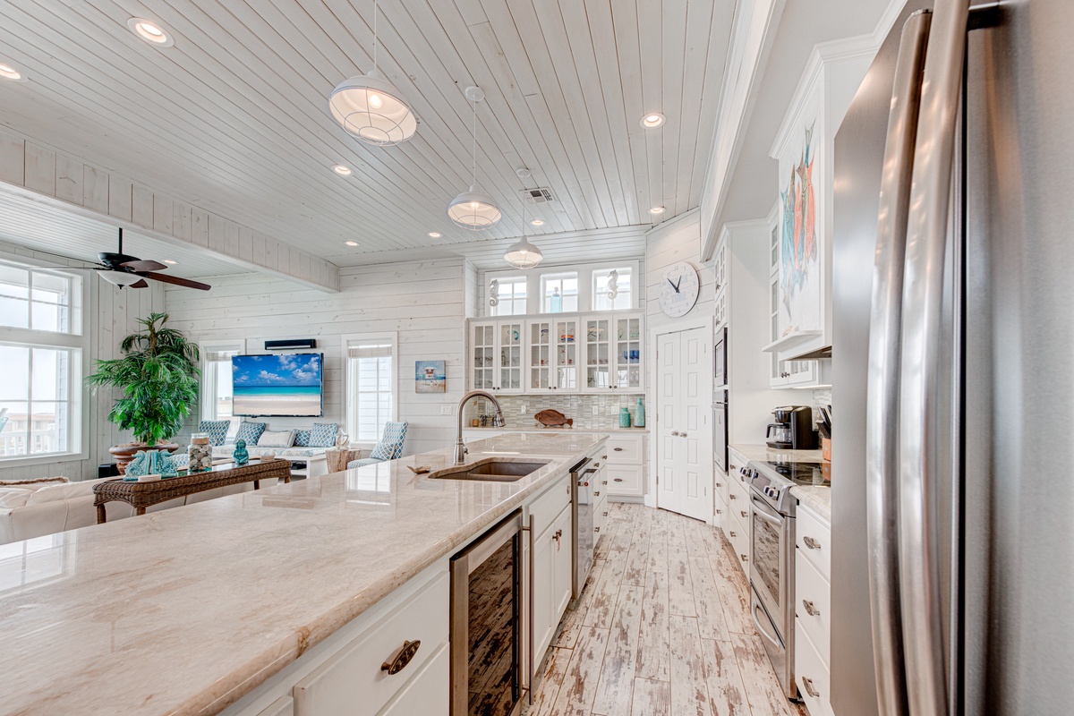 Your dream kitchen awaits with pristine white cabinetry, gleaming countertops, and top-tier appliances, flowing seamlessly into the comfortable living space.