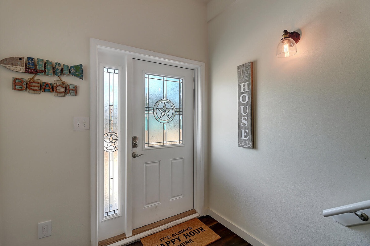 Step into your welcoming entrance where thoughtful beach-themed decor and warm lighting create an instant sense of home.