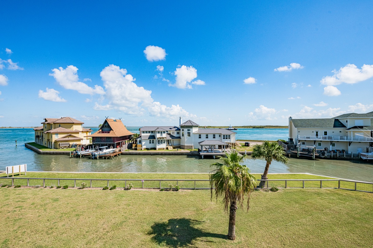 Waterfront homes line a peaceful canal with turquoise waters and pristine beaches beyond.