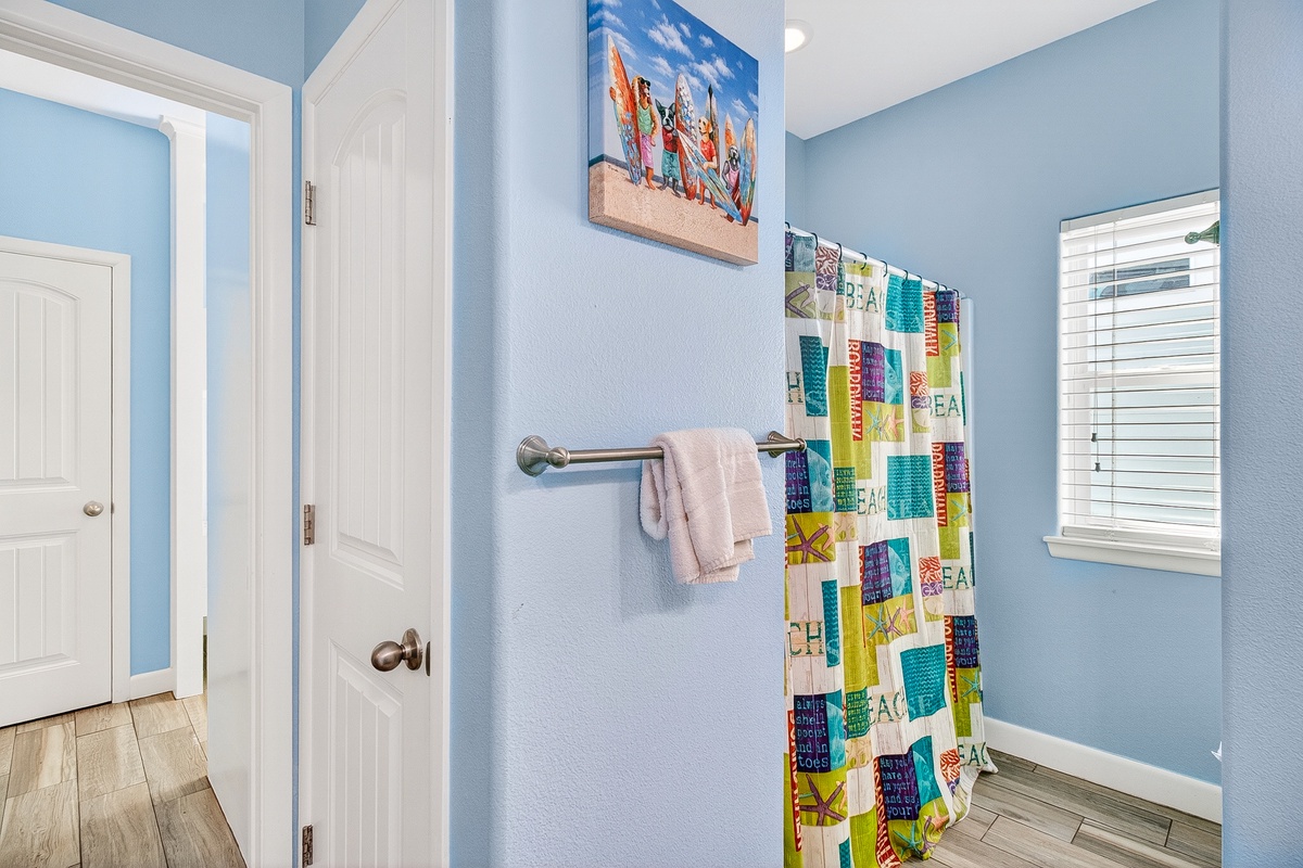 Step into your cheerful coastal bathroom with soothing blue walls and tropical touches that make every morning feel like vacation.