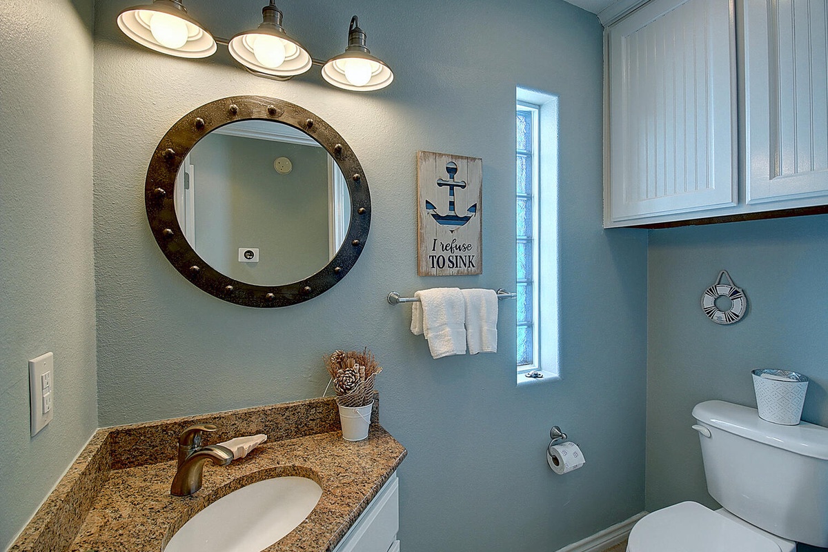 Refresh in this charming nautical bathroom with granite counters, coastal decor, and thoughtful lighting that makes your morning routine feel like a seaside retreat.