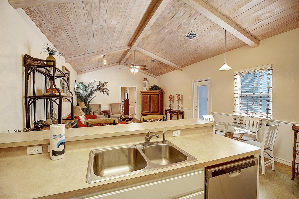 Your open-concept kitchen flows seamlessly into the living space, featuring exposed beam ceilings and warm natural light for comfortable meal prep.
