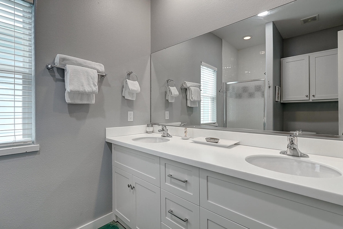 Your spacious bathroom features dual sinks and fresh towels, perfect for getting ready together each morning.