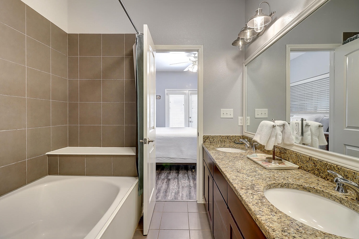 Your elegant master bathroom features granite double vanities, a soaking tub, and modern finishes for the perfect morning routine.