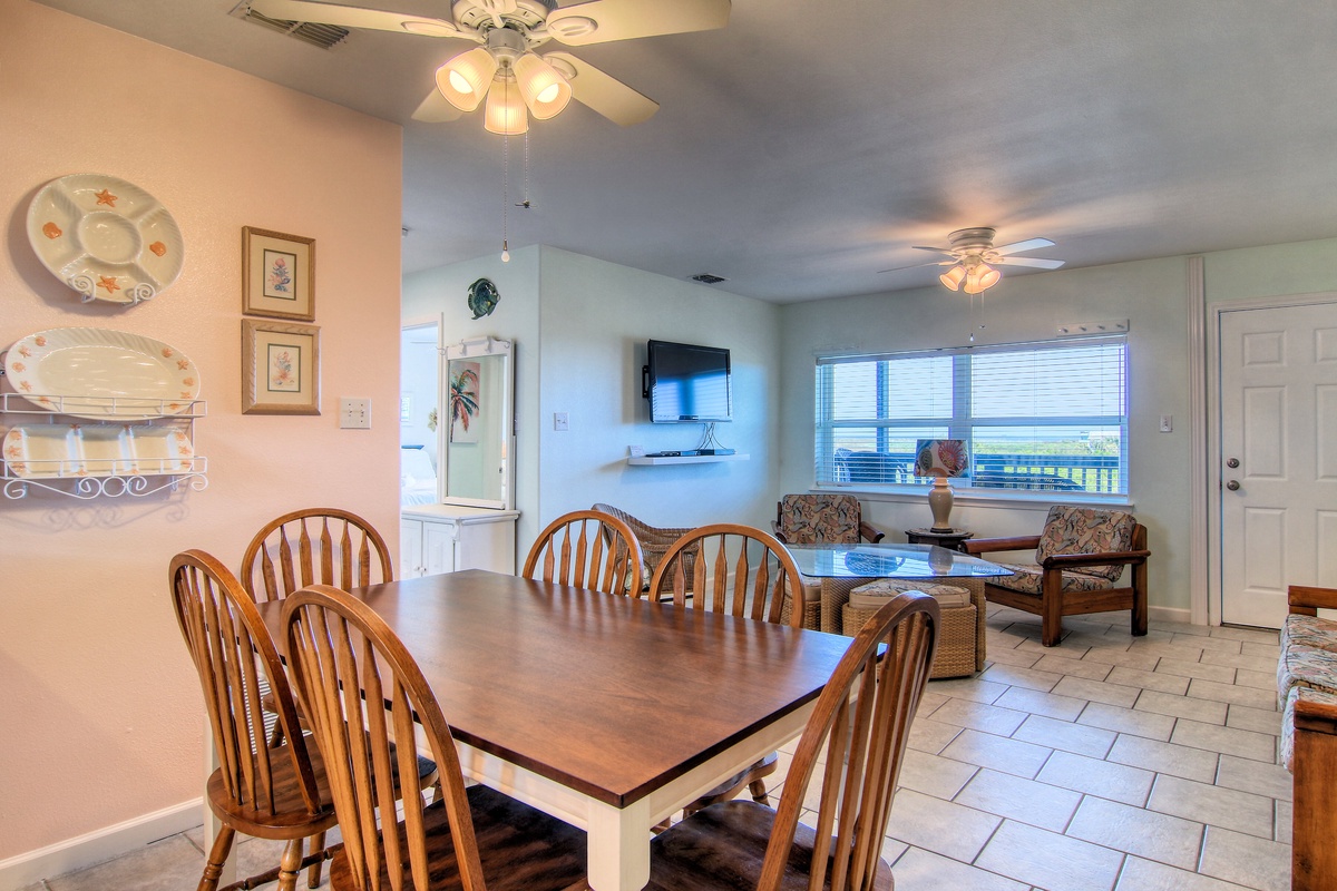 Gather around your spacious dining table for memorable meals while enjoying ocean views through expansive windows in this bright, welcoming space.
