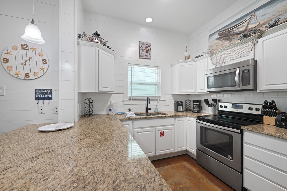 Your fully equipped kitchen features granite countertops, stainless steel appliances, and charming coastal decor to make cooking feel like home.