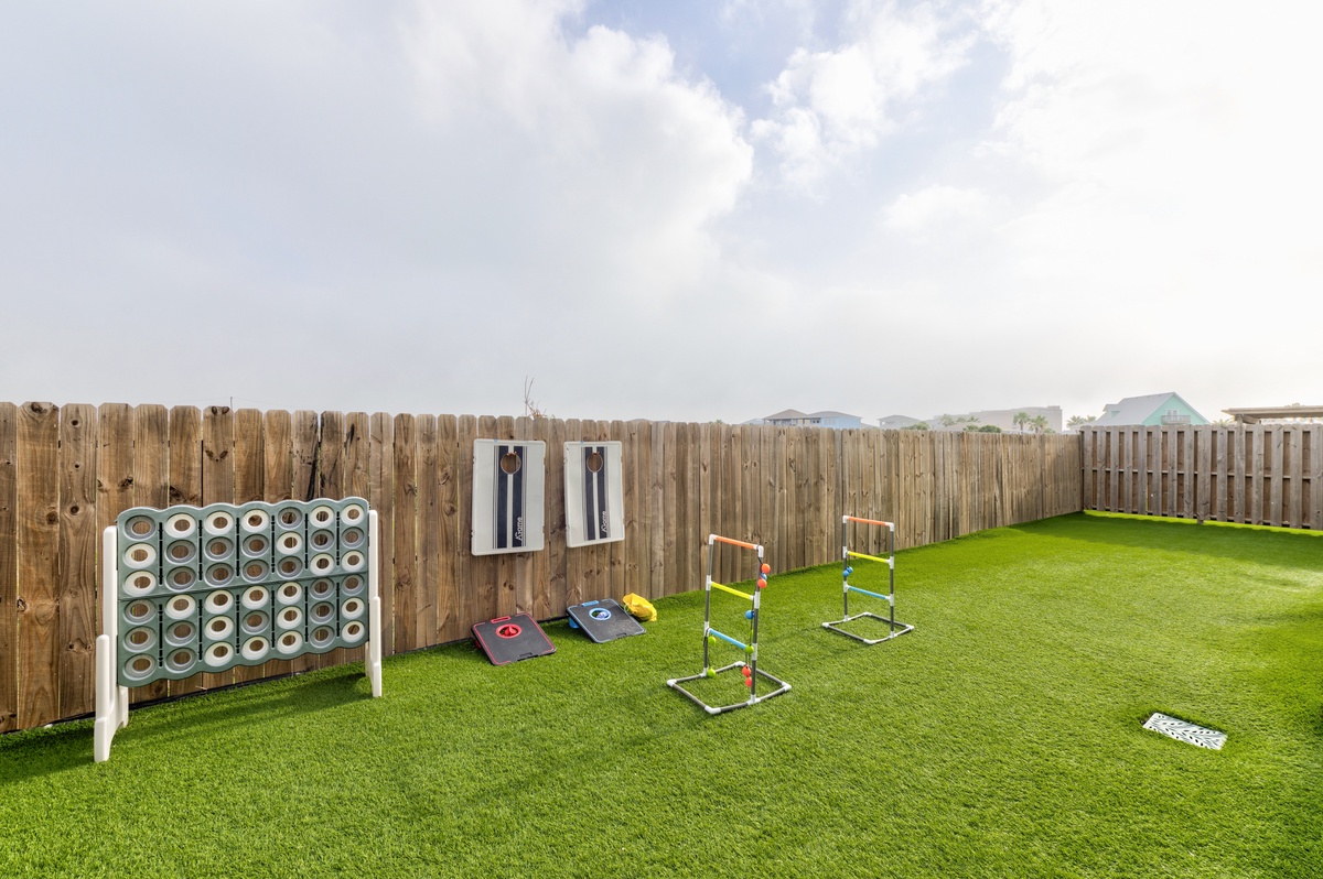 Your private backyard features fun lawn games including Connect Four, cornhole, and ladder toss on pristine artificial turf.