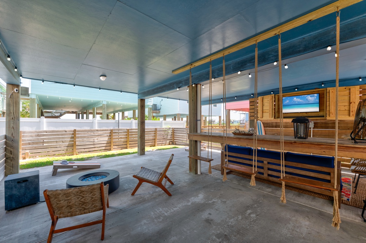 Unwind in your private covered patio, complete with relaxed seating, a fire pit, and a wooden swing—perfect for morning coffee or starlit evenings in your fenced backyard.