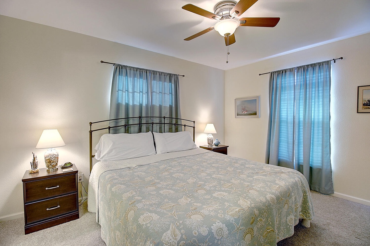 Drift off peacefully in this serene bedroom with soft lighting, gentle ceiling fan, and calming blue accents that create your perfect retreat.