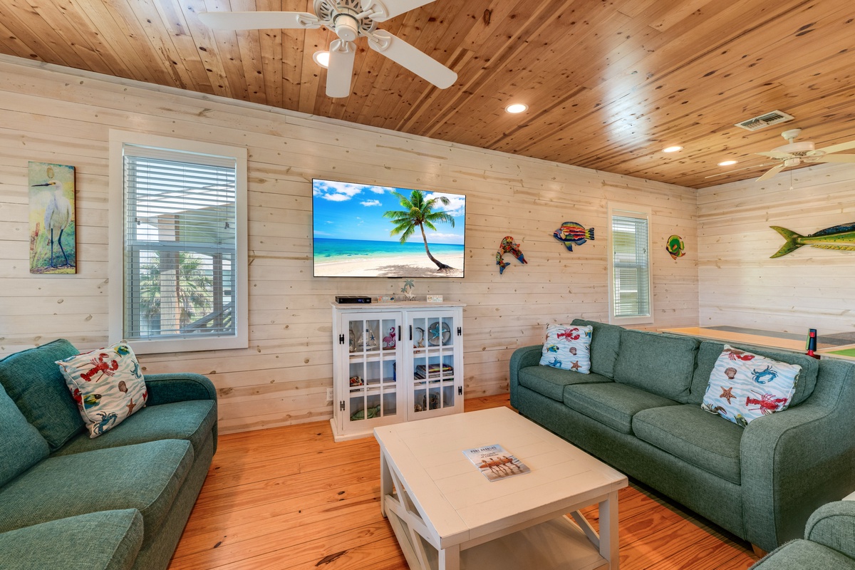 Unwind in your charming living room with cozy green sofas, warm wood details, and tropical touches that make you feel right at home.