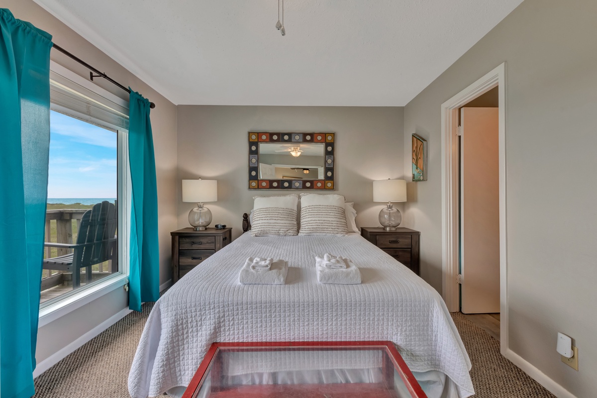 Drift off in your cozy bedroom with crisp linens, soft lighting, and refreshing ocean breezes through your private balcony door.
