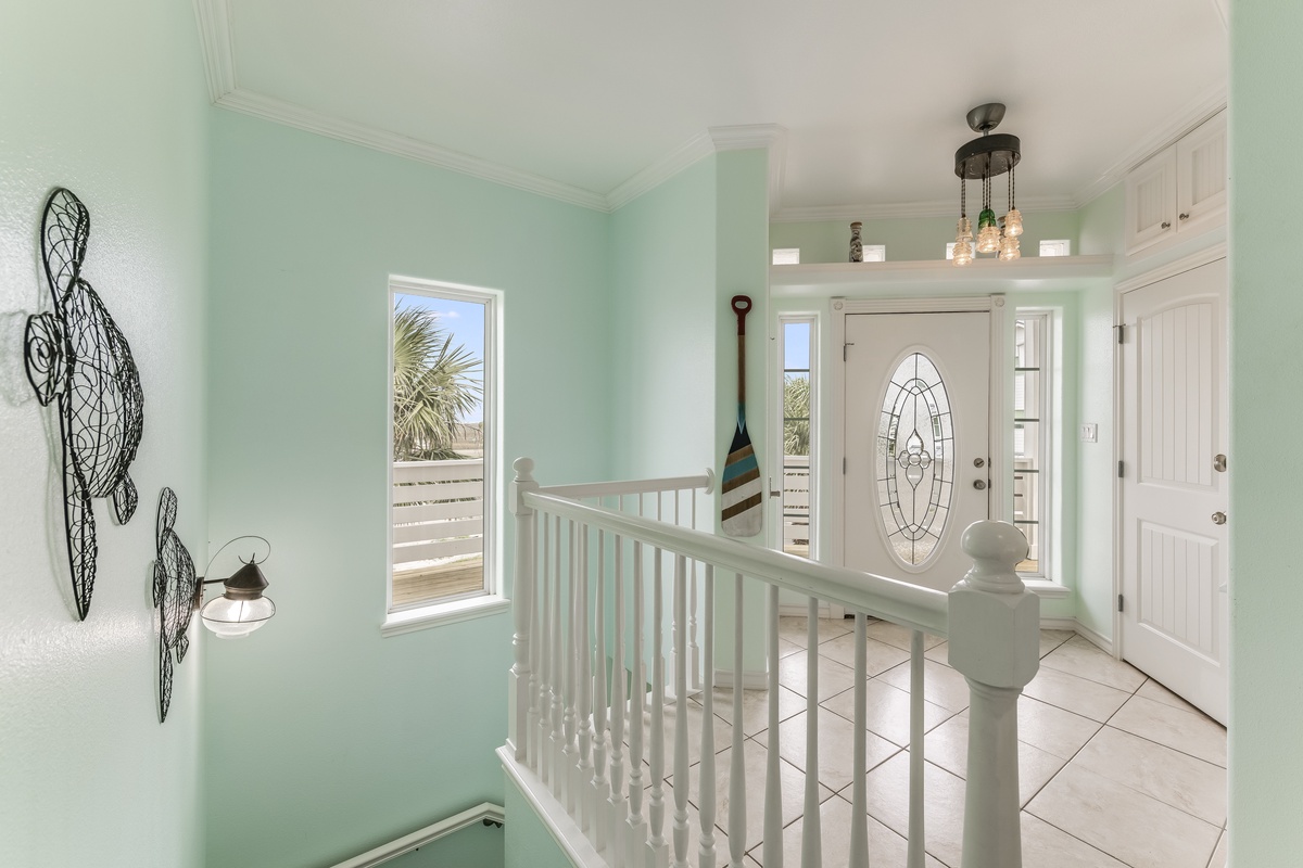 Step into your coastal retreat where sea-foam walls and nautical touches welcome you. Sunlight streams through windows revealing glimpses of paradise beyond.