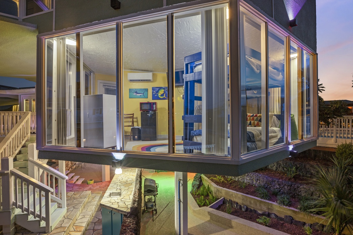 Step into your glass-enclosed retreat where floor-to-ceiling windows frame breathtaking sunset views while you relax in comfort.