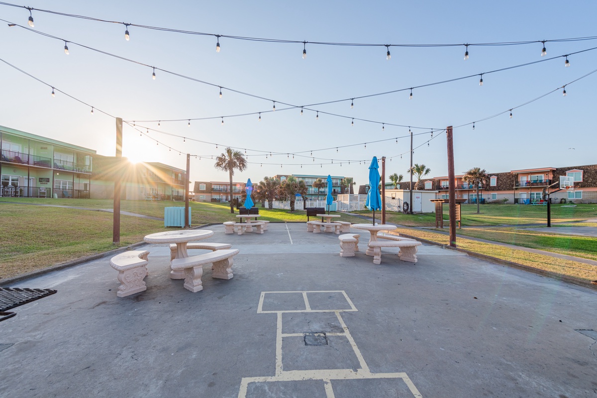 Step outside to your own game court with hopscotch painted right on the ground, perfect for family fun under twinkling string lights.