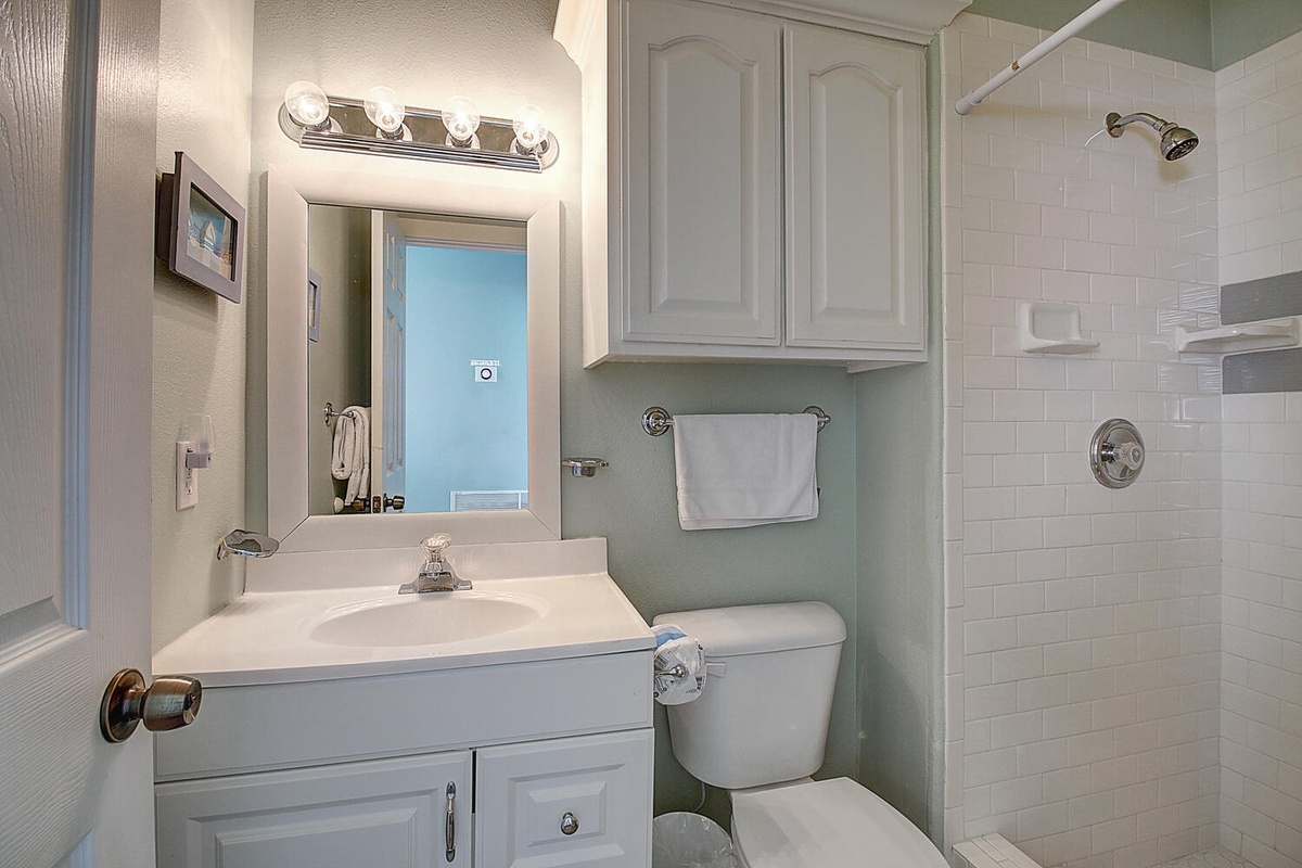 Your pristine bathroom offers bright vanity lighting, fresh towels, and a walk-in shower for refreshing mornings.