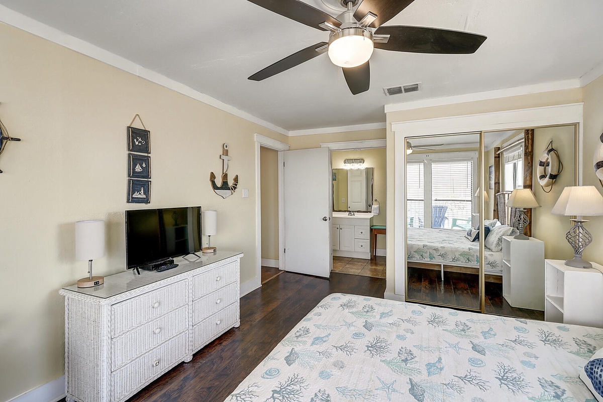 Unwind in your coastal-themed bedroom featuring nautical décor, flat-screen TV, and sliding doors to your private space.