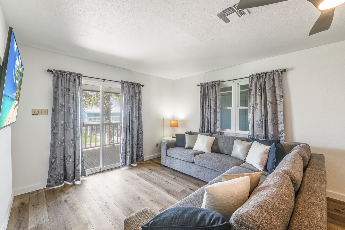 Unwind on plush sectional seating while gentle breezes flow through sliding doors to your private balcony overlooking tropical palms.