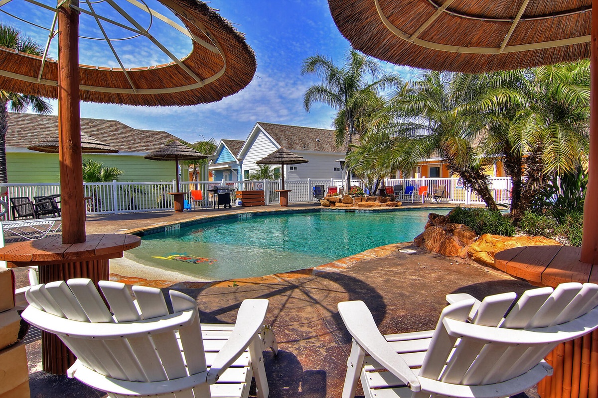 Relax in tropical paradise by your private pool with thatched umbrellas and comfortable lounge chairs under swaying palms.